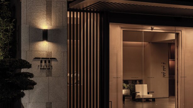 A modern building entrance with a glass door, a reception desk, and a seating area. - Younch Hotel Xi'An (Xi'an)