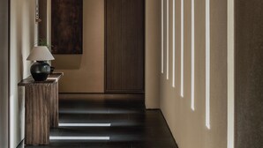 A modern hallway with a wooden floor, a lamp on a side table, and a framed artwork on the wall. - Younch Hotel Xi'An (Xi'an)