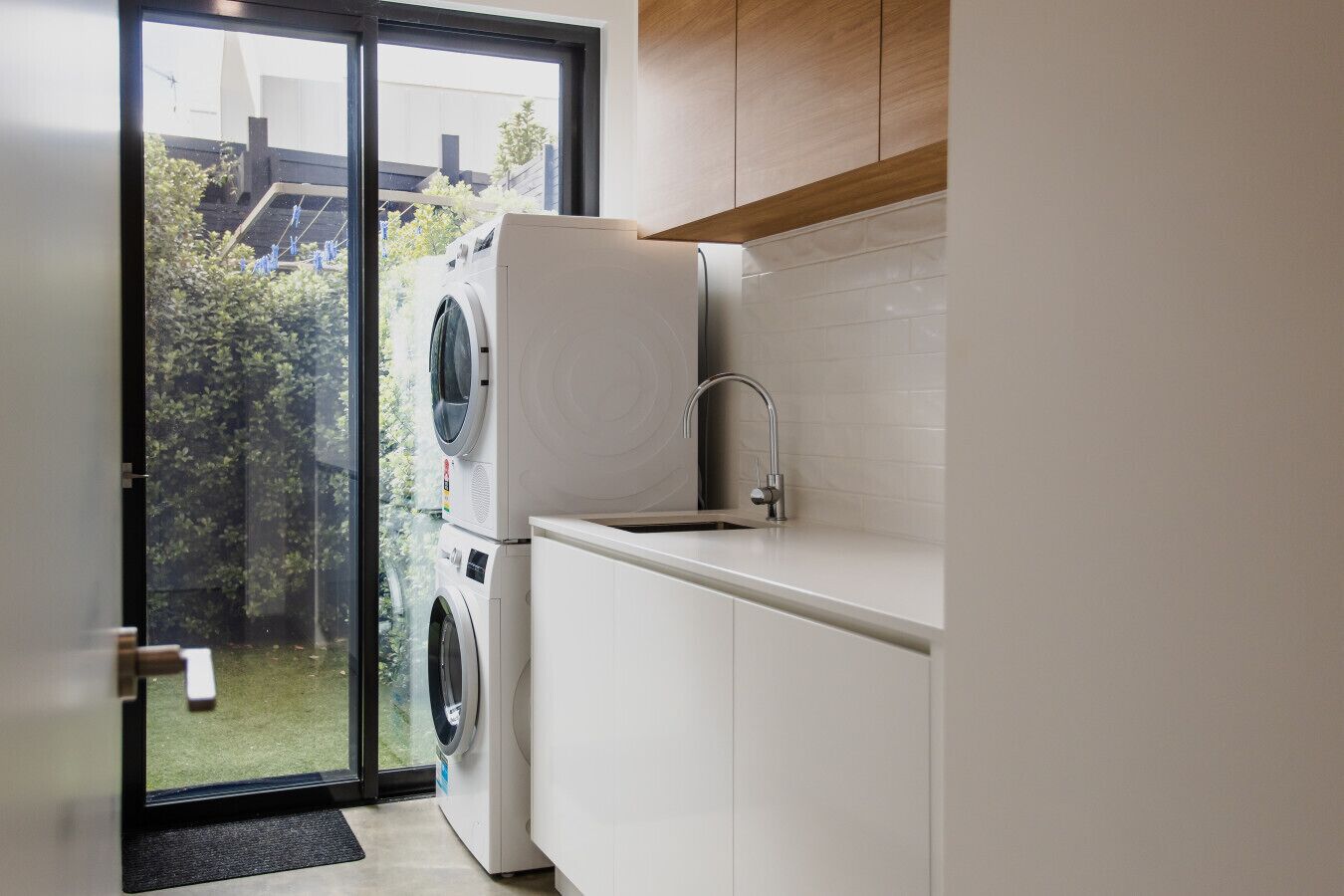 Bright laundry with washer, dryer, and direct outdoor access