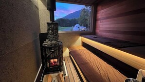 A cozy cabin interior with a stone fireplace, a bench, and a window overlooking a mountainous landscape. - SAUNA&Villa takibi (Makkari-mura)