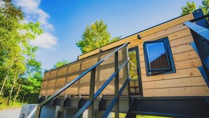 A wooden cabin with a window and a staircase leading to the entrance. - SAUNA&Villa takibi (Makkari-mura)