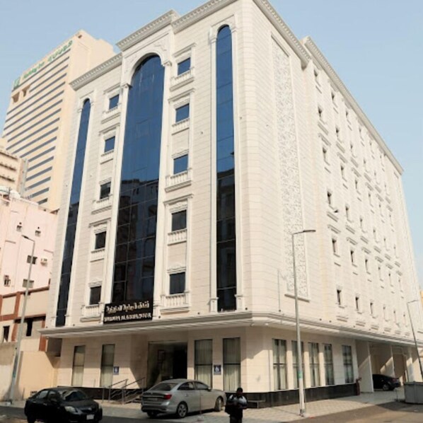 A multi-story building with a prominent arched entrance and a large glass facade.
