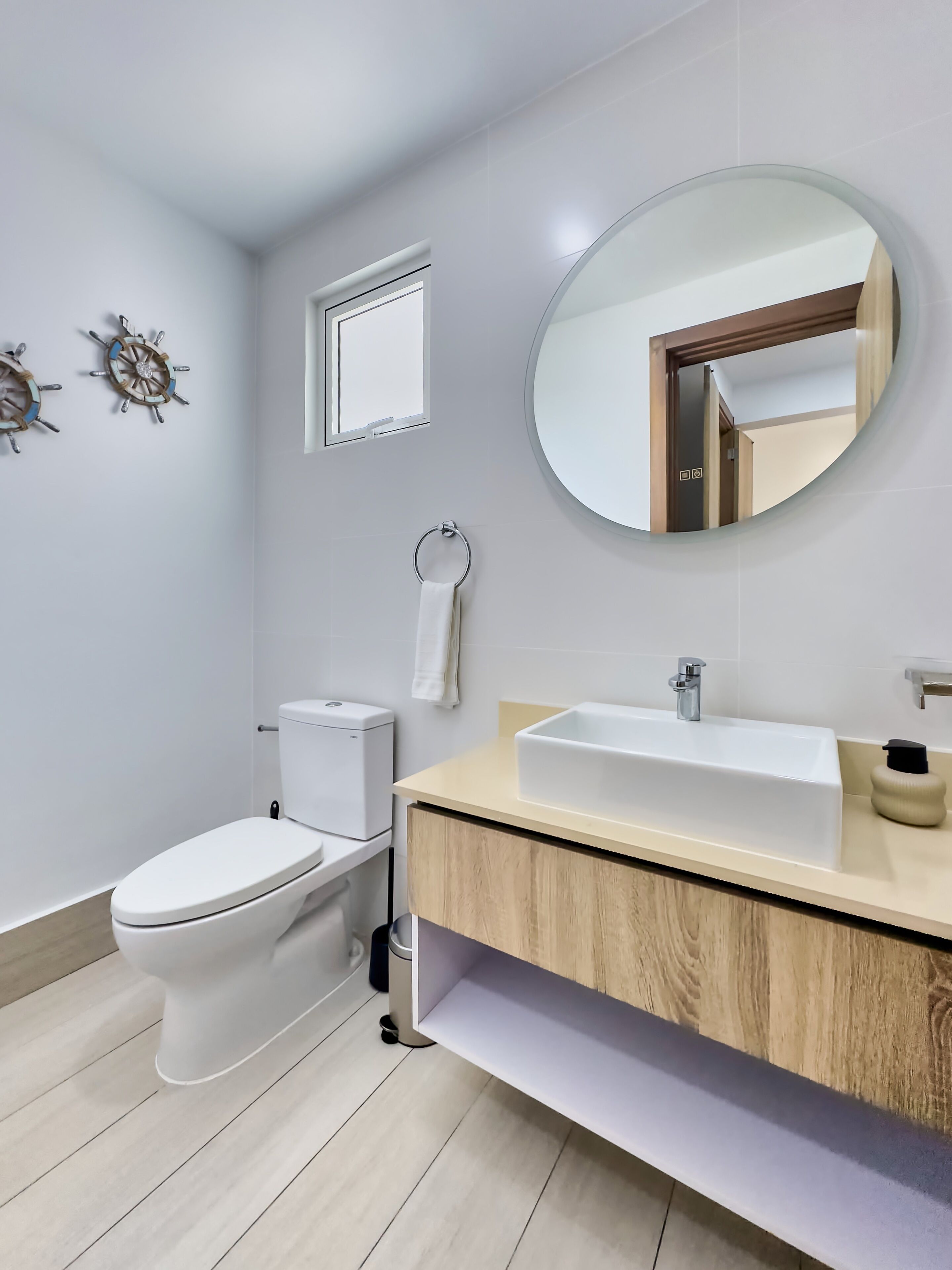 A modern bathroom with a toilet, sink, and mirror.