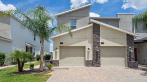 A modern two-story house with a garage, numbered 977 and 979, featuring a stone accent wall and a paved driveway.