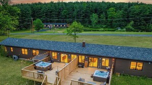 Un moderno alojamiento con terraza, jacuzzi y varias habitaciones para huéspedes.