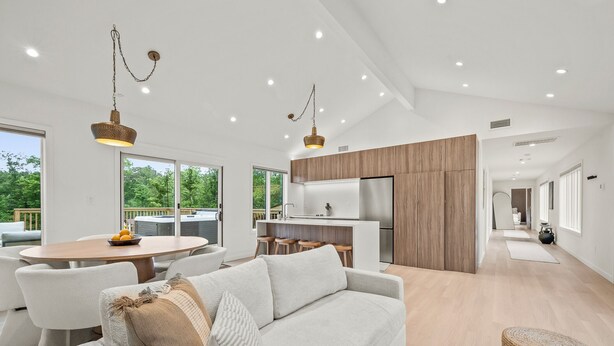 Una cocina moderna con armarios de madera, una isla central y un refrigerador de acero inoxidable.