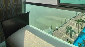 A room with a large window overlooking a body of water, a patterned wall, and a chair. - Deluxe Apartment with Guayas River view in Puerto Santa, Guayaquil (Guayaquil)