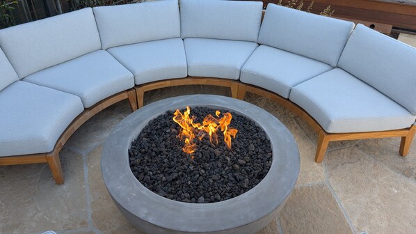A curved outdoor seating area with a central fire feature.