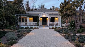 A house with a porch, a front door, and a gravel driveway. - Beautiful Magical Historic Webster House at Eleison Farms - Avocado Ranch 3 BD/2 BA (Carpinteria)
