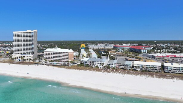 Eine Küstenstadt mit einem markanten Hotel, Zugang zum Strand und einem Winn-Dixie Geschäft.