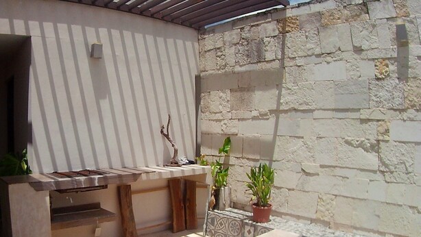 An outdoor patio with a stone wall, a grill, and a small pool. - Cozy 4-Sleeper Getaway w/ Pool & Laundry - Prime Mérida Mexico Stay!🌴 (Mérida)