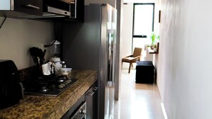 A modern kitchen with dark cabinets, a granite countertop, and stainless steel appliances. - Cozy 4-Sleeper Getaway w/ Pool & Laundry - Prime Mérida Mexico Stay!🌴 (Mérida)