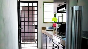 A kitchen with a stainless steel refrigerator, a sink, and a window with a plant on the counter. - Cozy 4-Sleeper Getaway w/ Pool & Laundry - Prime Mérida Mexico Stay!🌴 (Mérida)
