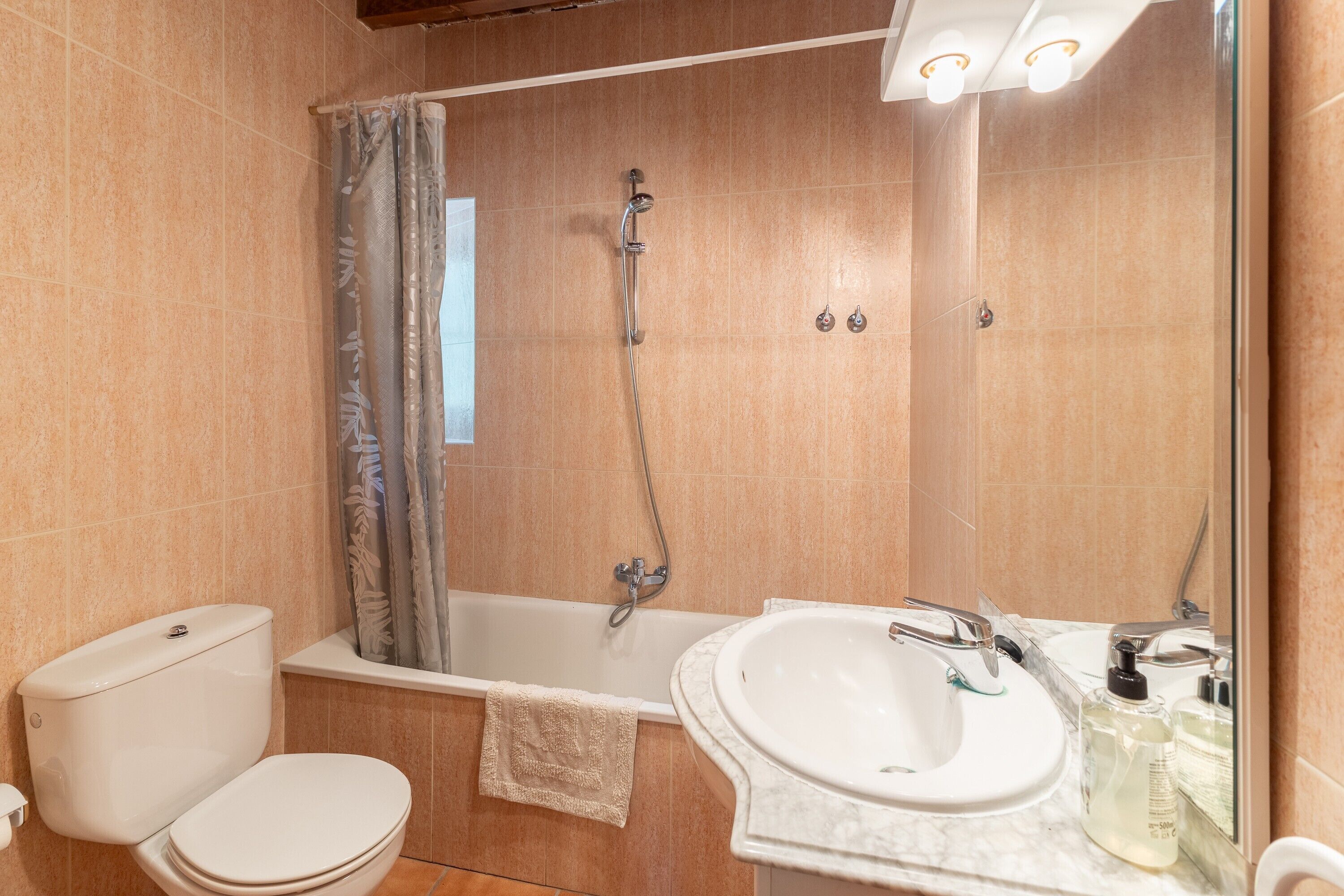 A bathroom with a toilet, bathtub, and sink.