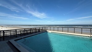 A swimming pool with a view of the beach and ocean.