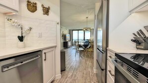 A modern kitchen with white subway tiles, stainless steel appliances, and decorative wall art.