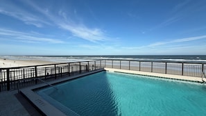 Piscina com vista para a praia e para o oceano.