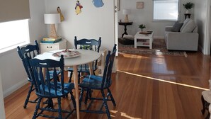 A dining area with a round table and chairs, a lamp, and wall decorations. - Cosy Corio Gateway - 2 Mins to Spirit of Tasmania (Corio)