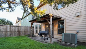 A backyard with a wooden pergola, a grill, and a large air conditioning unit. - Spacious Family Gem: Near NRG Stadium-Med Center - Pool Table - BBQ -11guests (Houston)