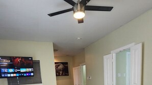 A bedroom with a bed, a ceiling fan, a TV, a window, and a door. - Spacious Family Gem: Near NRG Stadium-Med Center - Pool Table - BBQ -11guests (Houston)