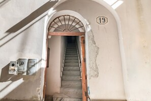 A stairway leading to a room with the number 19 on the wall, a door, and a security panel on the wall.