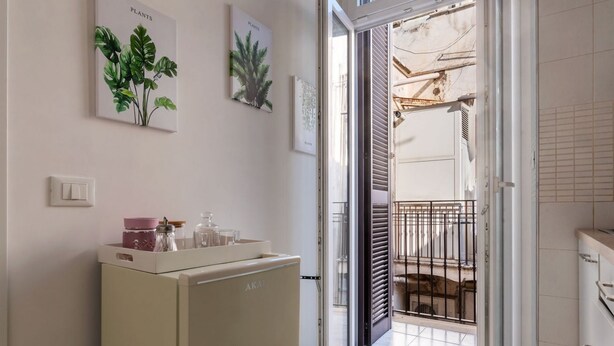 A hallway with a vintage-style refrigerator, a door leading to a balcony, and two framed botanical prints on the wall. - GuestHost - Sweety Apartment near MM Ottaviano (Roma)