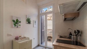 A kitchen with a built-in oven, a sink, and a window overlooking a balcony. - GuestHost - Sweety Apartment near MM Ottaviano (Roma)