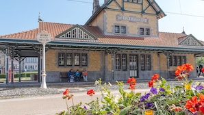 Una estación de tren histórica con un andén cubierto y un edificio que dice 