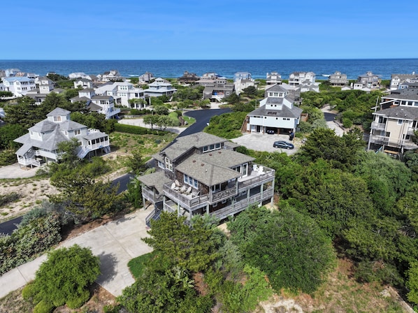 A coastal residential area with houses featuring balconies and a view of the ocean.
