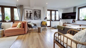 A spacious living room with a sofa, armchairs, a television, and artwork on the walls. - Beautiful private villa for 20 people with WIFI, TV, patio and panoramic view (Koscielisko)