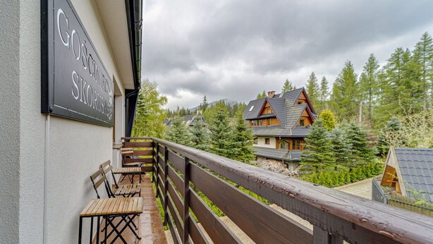 A wooden deck with benches, a sign reading "Gosum Hotel Skorus", and a view of a traditional wooden house surrounded by trees. - Beautiful private villa for 20 people with WIFI, TV, patio and panoramic view (Koscielisko)