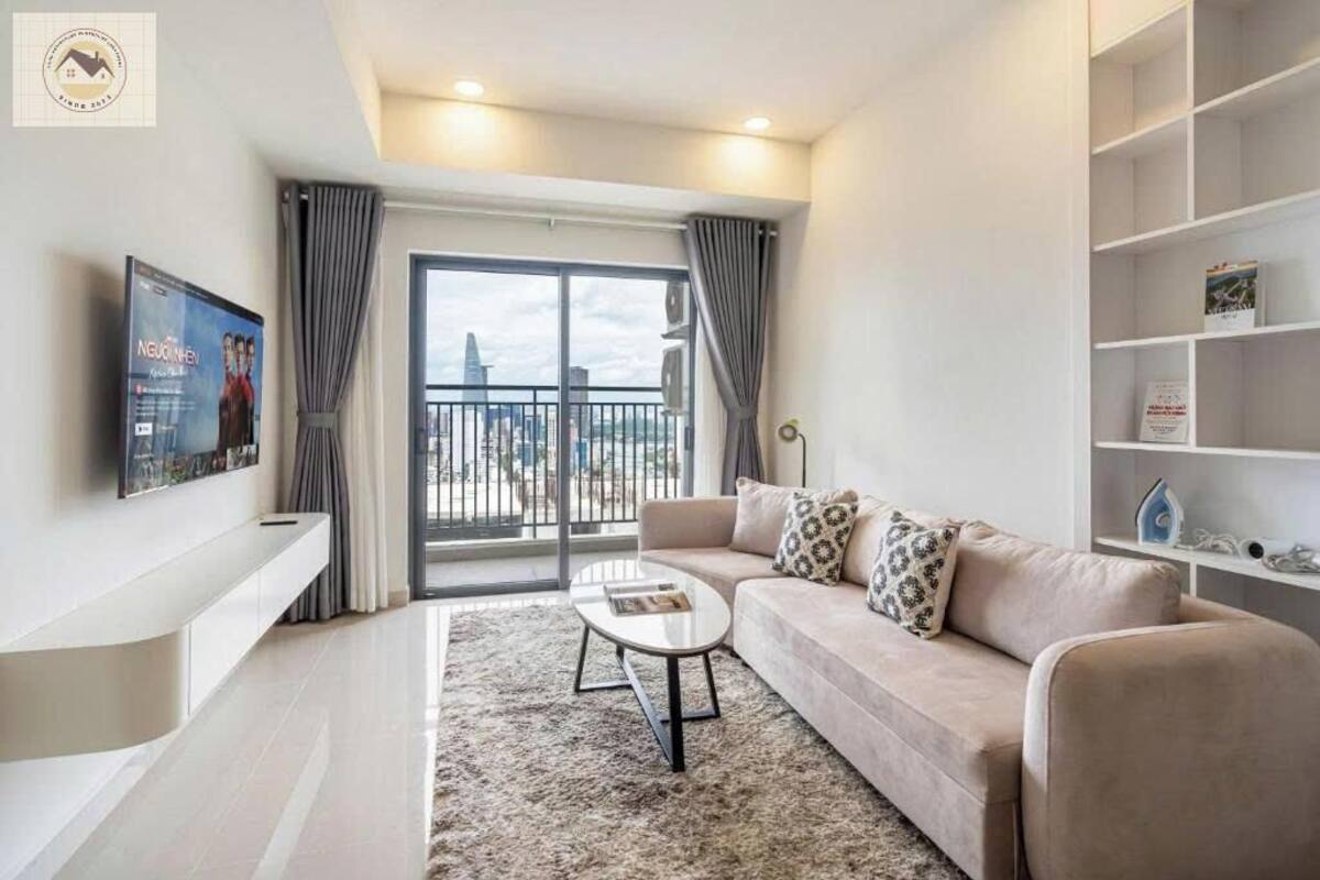 A modern living room with a sofa, a coffee table, and a TV mounted on the wall.