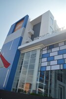 Un edificio moderno con un llamativo letrero 'BROMO PARK', amplias ventanas de vidrio y una fachada distintiva azul y blanca.