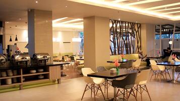 A modern dining area with a buffet, seating arrangements, and a decorative wall.