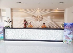 A reception desk with a modern design, featuring a geometric pattern on the counter and a decorative wall with a striped pattern and circular designs.
