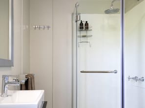 A modern bathroom with a glass-enclosed shower, a white sink, and a towel rack. - Chobe Princesses By Mantis (Kasika)