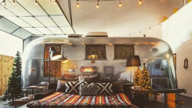 Une chambre confortable avec un lit, une petite table et un sapin de Noël.