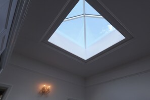 A skylight in a room with white walls and a chandelier. - The Shobnall House - Newly Refurbished, 5 Bedrooms (Burton on Trent)