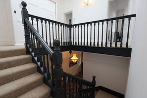 A staircase with black balusters and a handrail, leading to an upper floor. - The Shobnall House - Newly Refurbished, 5 Bedrooms (Burton on Trent)