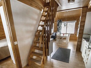 A wooden interior with a staircase, a dining area, and a kitchen. - Puolukka 2 by Interhome (Loviisa)