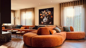 Un soggiorno moderno con un divano componibile, un tavolino da caffè e un quadro con fiori sulla parete.