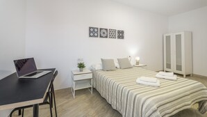 A bedroom with a bed, a desk with a laptop, a wardrobe, and three wall-mounted decorative items. - Vacation 'Ifae 3' with Wi-Fi (Guía de Isora)
