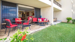 A balcony with outdoor furniture, a grassy area, and a building facade. - Sugar Beach #131: Front-row views, salty air & instant beach access—pure Maui! (Kihei, Maui)