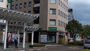 Un hotel con varios pisos, una entrada cubierta y un letrero que indica que es un hotel.