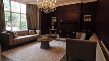 A living room with a sofa, armchair, coffee table, and fireplace.