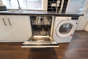 Un lave-vaisselle Bosch installé sous un plan de travail de cuisine, avec un lave-linge intégré.