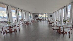 Ein geräumiger Konferenzraum mit weitreichendem Stadtblick, ausgestattet mit moderner Möblierung und einem Flachbildfernseher.