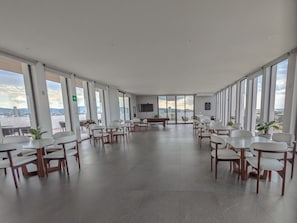 Ett rymligt konferensrum med en fantastisk panoramautsikt över staden, inrett med moderna möbler och en platt-TV.