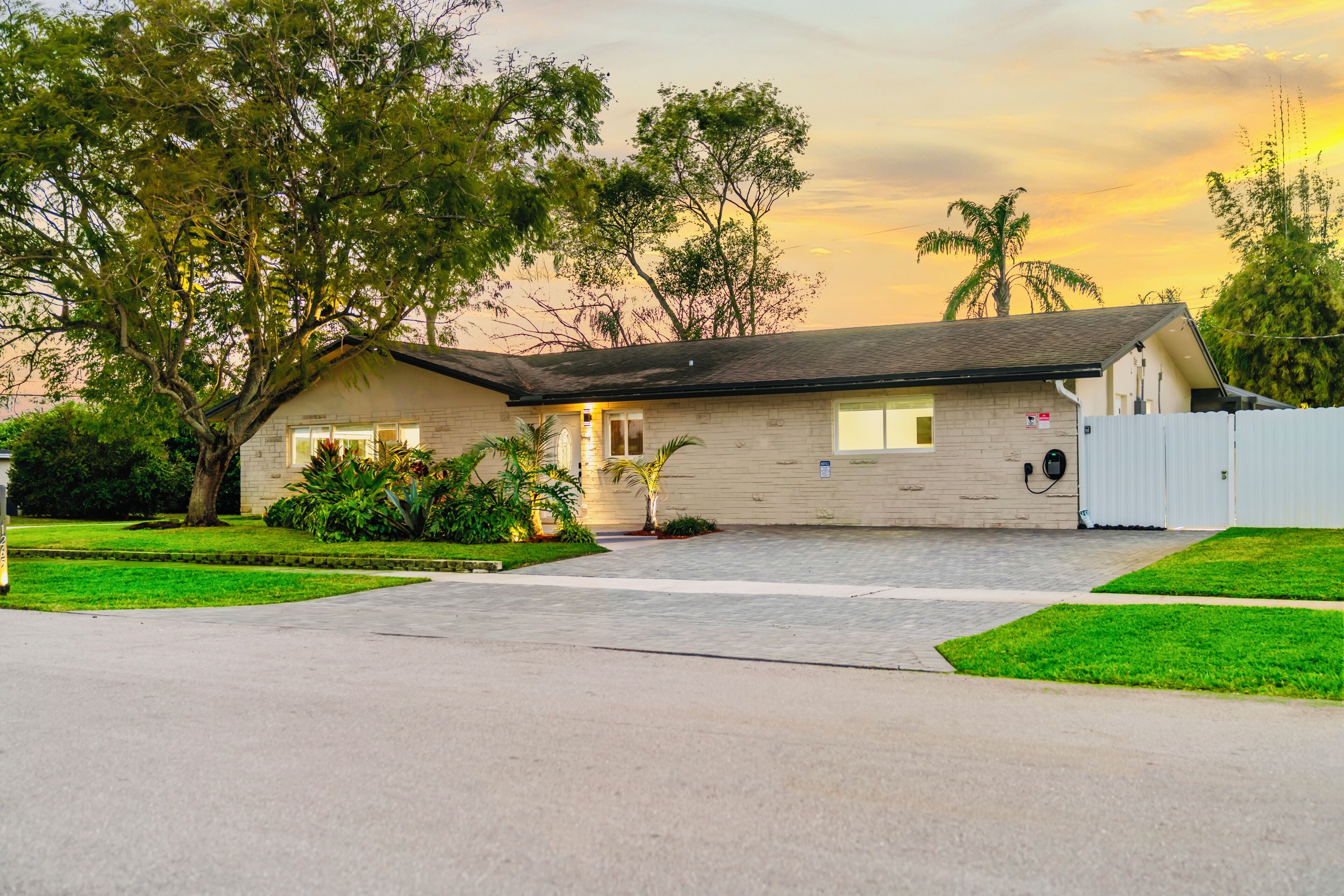 A single-story house with a front porch, a garage, and a fenced yard.