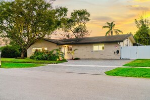 A single-story house with a front porch, a garage, and a fenced yard.